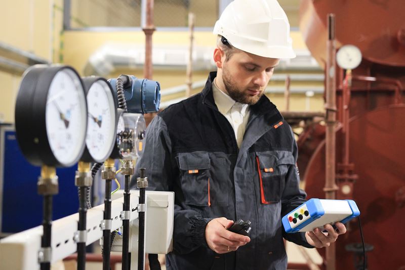 Male technician operator measuring pressure, temperature and flow on valves.